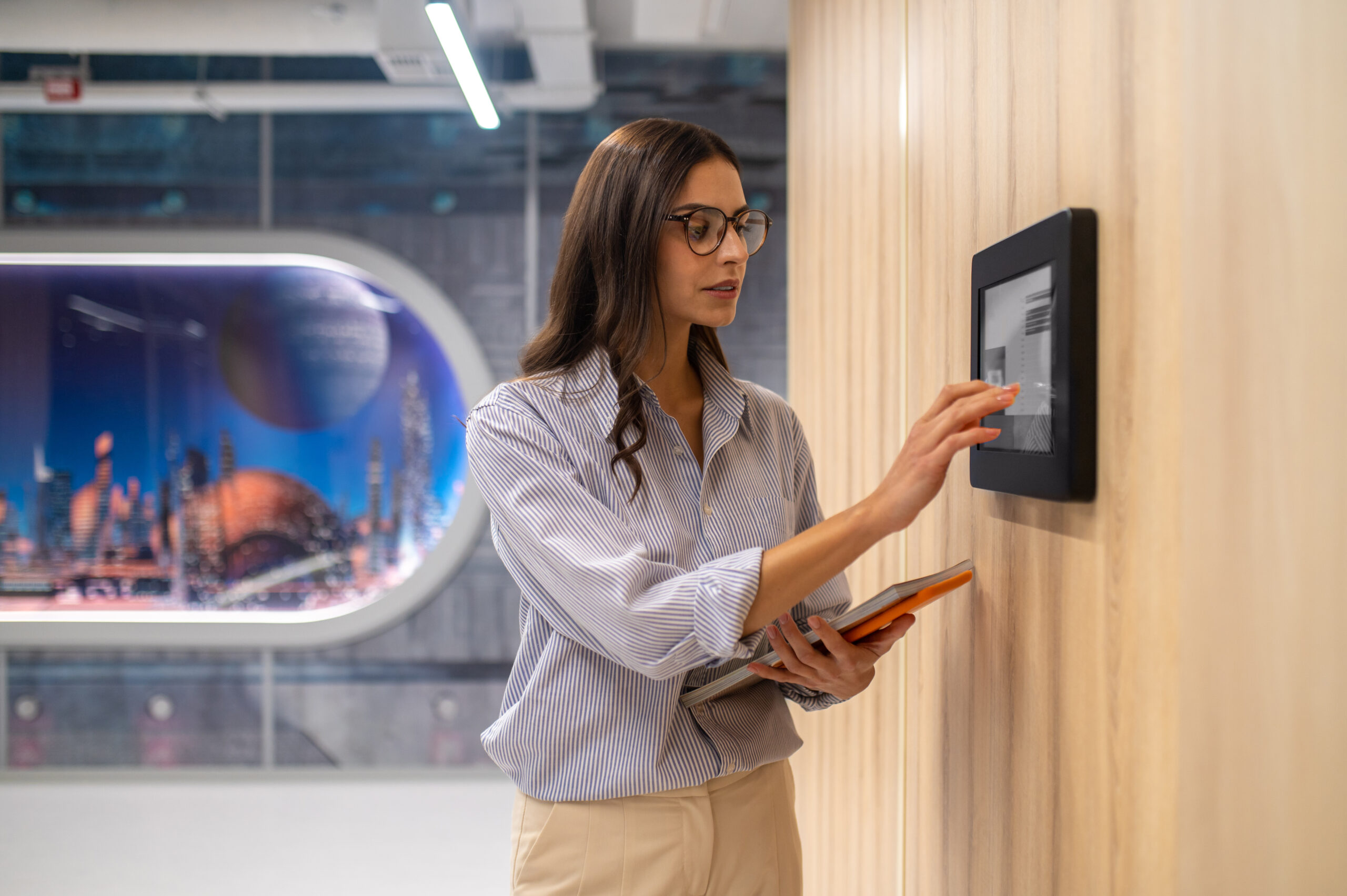 Woman touching control panel on wall in corridor | Sentor Controls